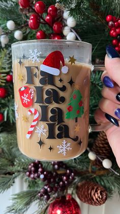 a person holding a coffee mug in front of a christmas tree with decorations on it