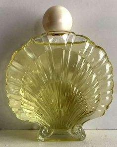 an empty glass bottle sitting on top of a white counter next to a wooden stopper