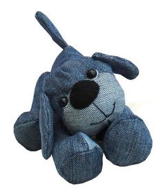 a blue dog stuffed animal sitting up against a white background