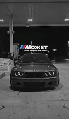 a black and white photo of a car parked in a garage with the mosket logo on it