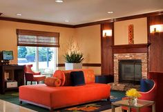 a living room filled with furniture and a fire place in front of a tv mounted on a wall