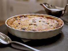 a pie sitting on top of a table next to two spoons