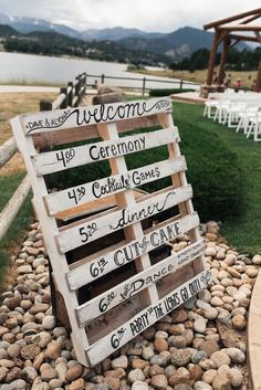 a wooden sign sitting on top of a pile of rocks