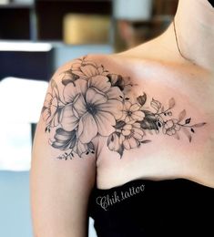 a woman's shoulder with flowers on it and the words ink tattoos written in cursive writing