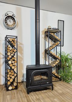 a wood burning stove sitting next to a stack of logs on top of a hard wood floor