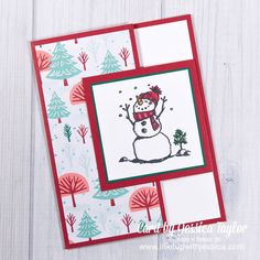 a christmas card with a snowman on it and trees in the background, which is also part of an envelope