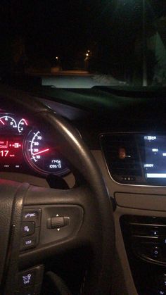 the dashboard of a car is lit up at night