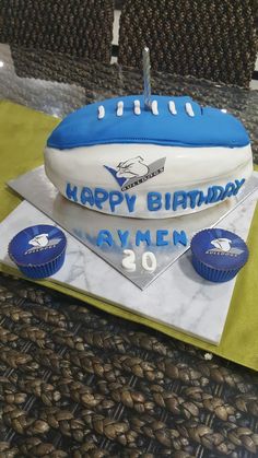 a football themed birthday cake with cupcakes on the side and blue frosting