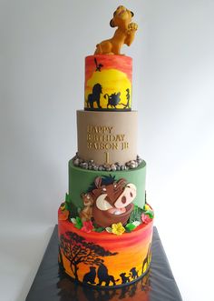 a three tiered birthday cake decorated with disney characters