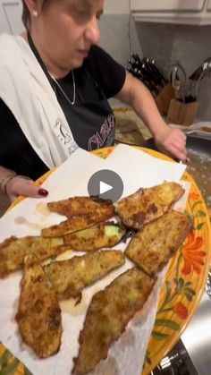 a woman is preparing food on a plate in the kitchen and she is looking at it