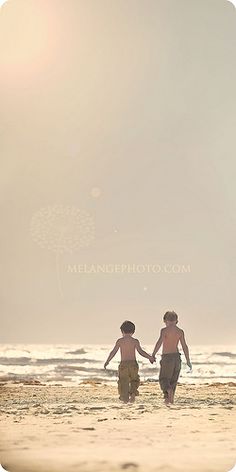 two people walking on the beach holding hands