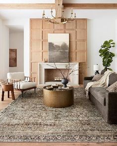 a living room filled with furniture and a large rug on top of a wooden floor