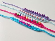 three crocheted bracelets with beads and beading on them sitting next to each other