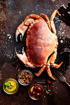 a large crab sitting on top of a table next to bowls of food