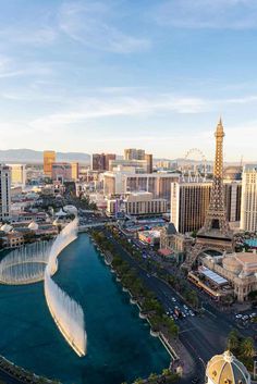 an aerial view of the las vegas strip with fountains and hotels in the background at sunset