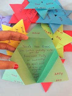 someone's hand holding up some origami pieces with the words save the date written on them