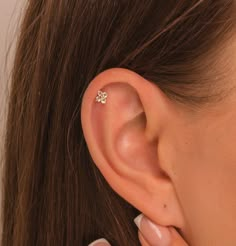 a close up of a person's ear with a small diamond in the middle