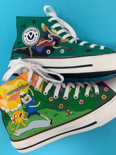 Custom, hand painted canvas boots inspired by your favorite characters from Adventure Time. Perfect for gift at any time of the year, they will not go unnoticed. You can always choose any other type of design or modify to taste the one you are seeing, they are made by freehand and each one is unique. The base color of the shoe is white, the paint is resistant to hand and machine washing but always cold, the color is protected with a coat of fixative at the end of dryer, bleach or other corrosive Fun Hand Painted High-top Sneakers, Fun Hand-painted High-top Sneakers, Green Hand Painted High-top Sneakers, Fun Hand Painted High-top Custom Sneakers, Adventure Time Shoes, Hand Painted Sneakers, Custom Painted Shoes, Painted Sneakers, Custom Converse