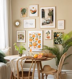 a small table with some fruit on it in front of a wall full of pictures