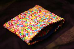 a colorful wallet sitting on top of a purple cloth