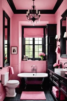 a pink bathroom with black and white fixtures, chandelier, toilet, sink and bathtub