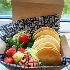 a box filled with lots of different types of food on top of a window sill