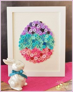 a white frame with buttons in the shape of an easter egg and a bunny figurine