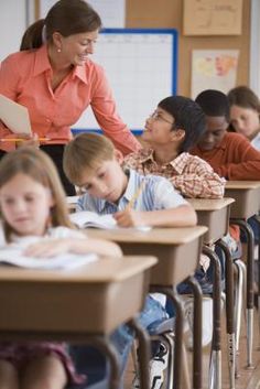 there are many children sitting at their desks in the classroom and one teacher is writing