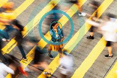 a woman talking on her cell phone in the middle of a crosswalk with lots of people