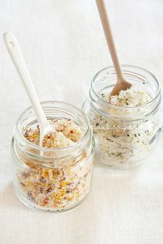 two jars filled with different types of food and one has a spoon in it to stir them