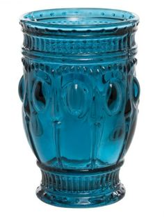 a blue glass vase sitting on top of a table