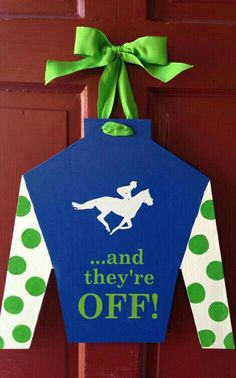 a door hanger that says and they're off with a horse on it