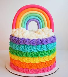 a rainbow cake with white frosting and icing