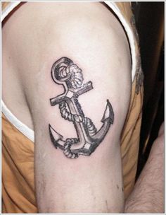 an anchor tattoo on the right arm and shoulder, with a skeleton holding a cross