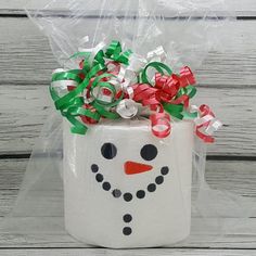 a snowman treat box is wrapped in plastic and tied with green, red, and white ribbons