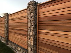 a wooden fence is shown with stone and wood panels on the top, along side it