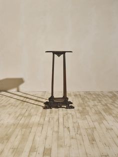 a small table sitting on top of a hard wood floor next to a white wall