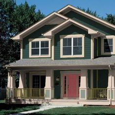 a two story house with green siding and yellow doors