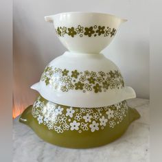 three green and white dishes stacked on top of each other