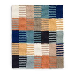 a multicolored knitted rug with squares and stripes on the bottom, in various colors