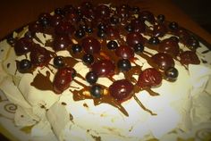 a close up of a cake with cherries on the icing and toppings