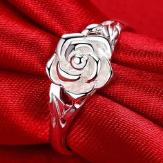 a rose ring sitting on top of a red cloth