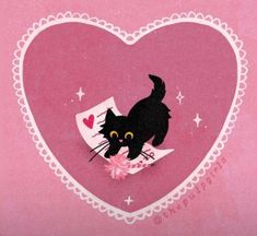 a black cat is sitting on top of a pink heart