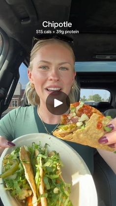 a woman holding a plate of food in her car