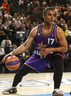 a man holding a basketball on top of a court