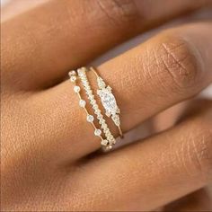 a woman's hand with three different rings on her finger and the ring has diamonds in it