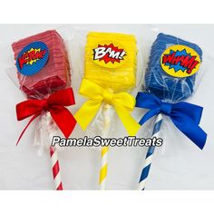 three lollipops wrapped in plastic wrappers with bows