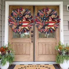 two patriotic wreaths on the front door of a house