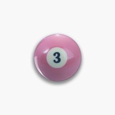 a pink billiard ball with the number three on it's side, against a white background