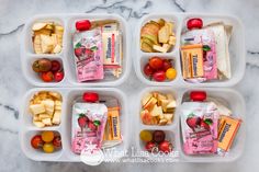 four plastic containers filled with different types of fruits and snacks on top of a marble counter